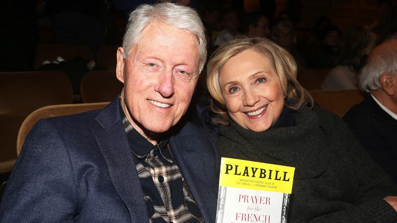 Bill and Hillary Clinton sit together smiling