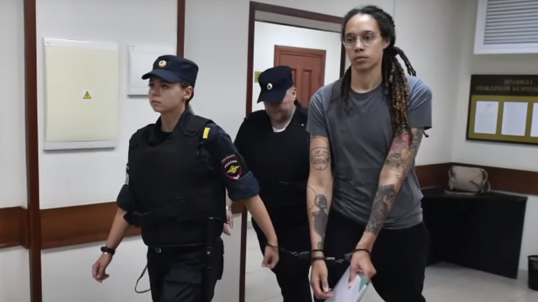 Brittney Griner being held in handcuffs