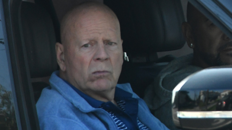 Bruce Willis sitting passenger side of a car