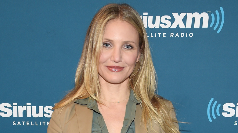 Cameron Diaz posing in a tan jacket at a SiriusXM event