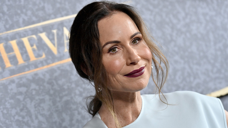 Minnie Driver poses in white outfit and plum-colored lipstick