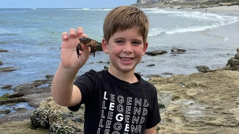 Brayden El Moussa holding up a small crab at the beach