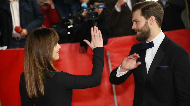 Dakota Johnson and Jamie Dornan giving each other a high-five