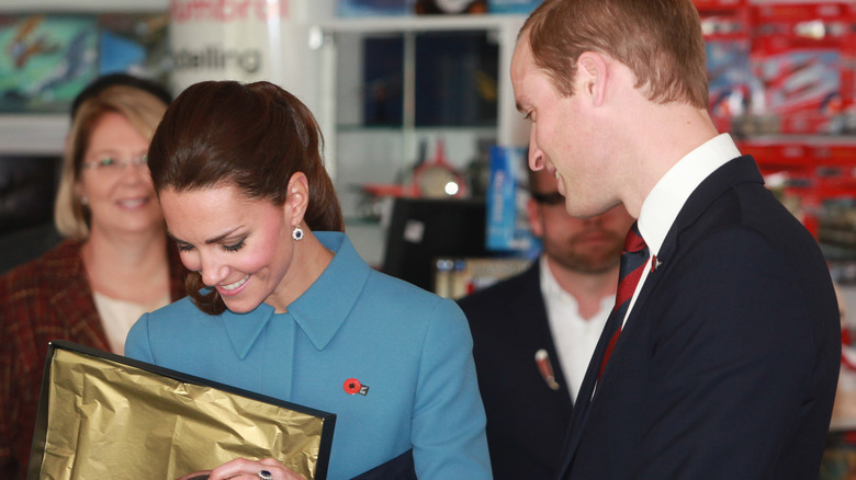 Prince William and Kate Middleton opening a gift