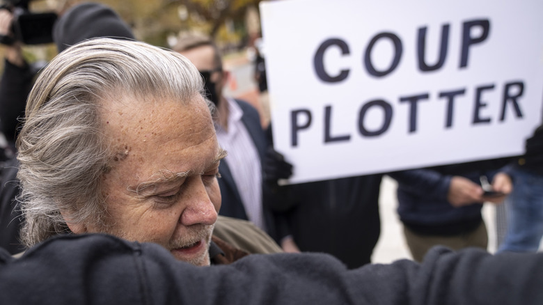 Steve Bannon arrested in front of "coup plotter" sign