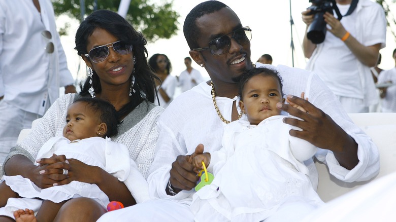 Kim Porter and Diddy sitting outdoors with their twins