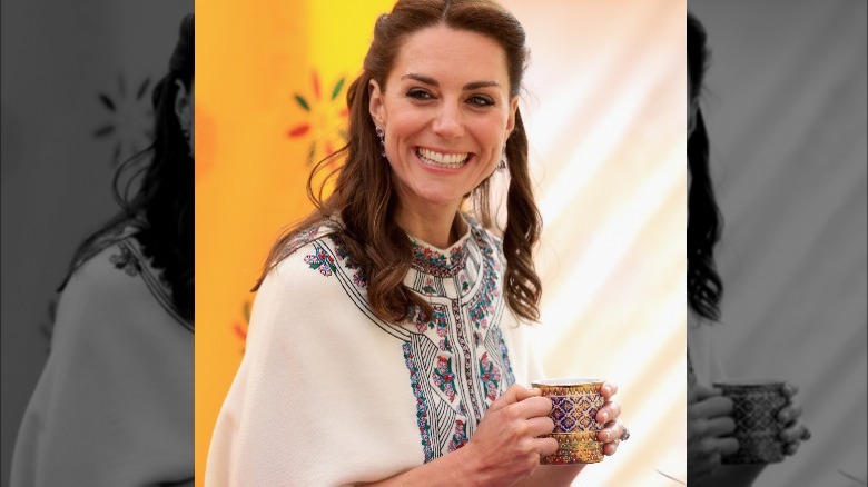 Kate Middleton holding cup smiling