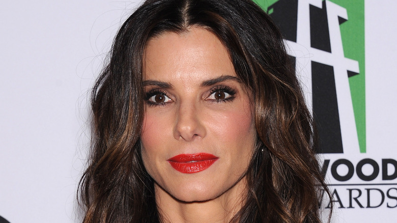 Sandra Bullock wears bold red lipstick at a red carpet event