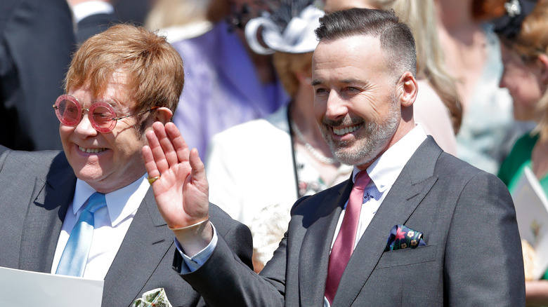 Elton John and David Furnish waving at Meghan Markle's wedding