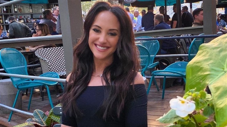 Emily Compagno with long, dark hair at an outdoor restaurant