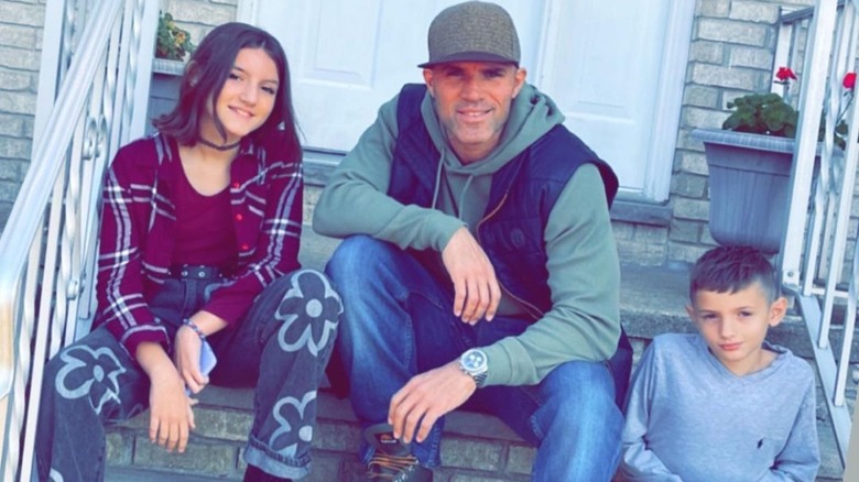 Gia, Enzo, and Nico Palumbo sitting and smiling on a set of stairs