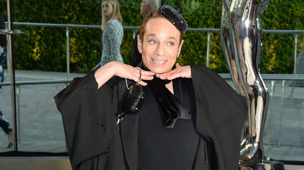 Chris Kattan smiling, holding his hands under his chin