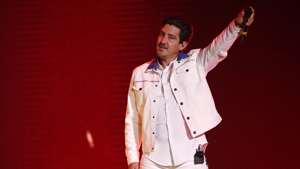 Jonathan Knight on stage with microphone