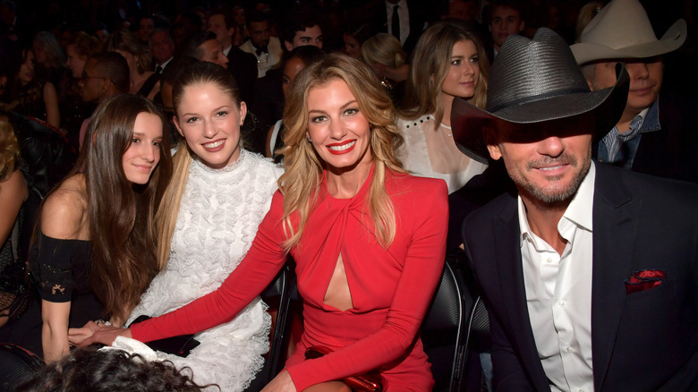 Faith Hill, Tim McGraw, Audrey and Maggie seated at an event