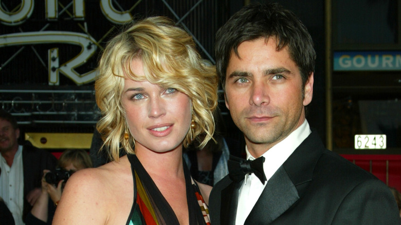 Rebecca Romijn and John Stamos posing