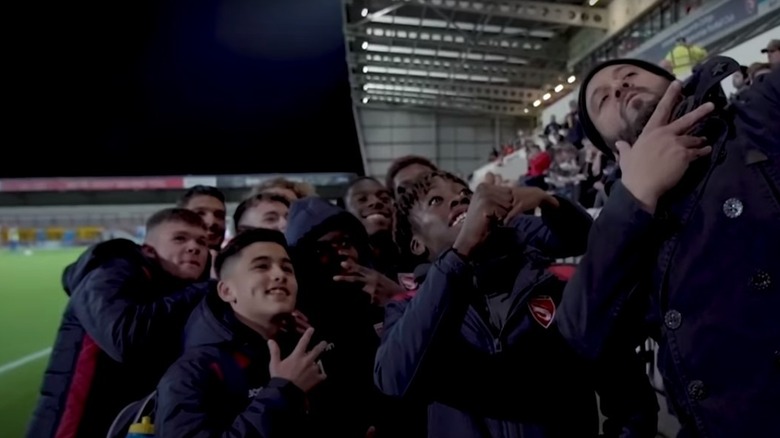 Adam Richman posing with fans at soccer match