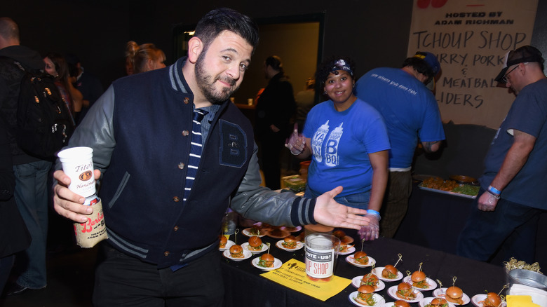 Adam Richman posing in front of food