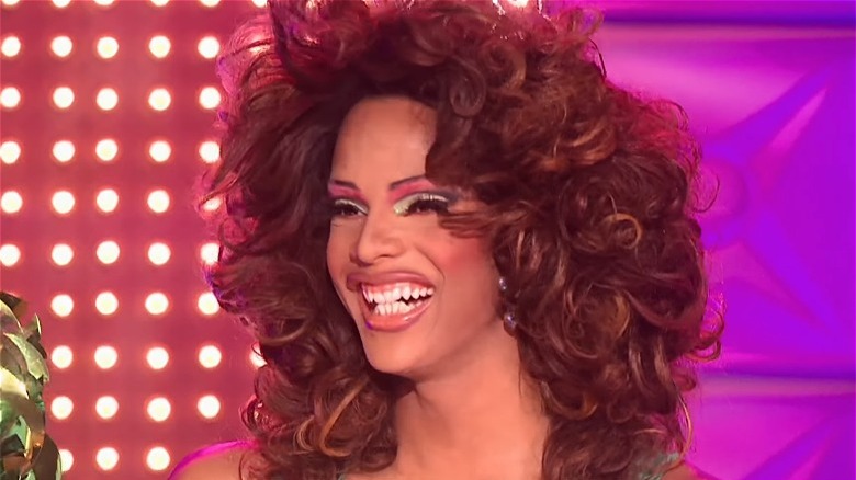 Tyra Sanchez smiling on Drag Race runway big hair