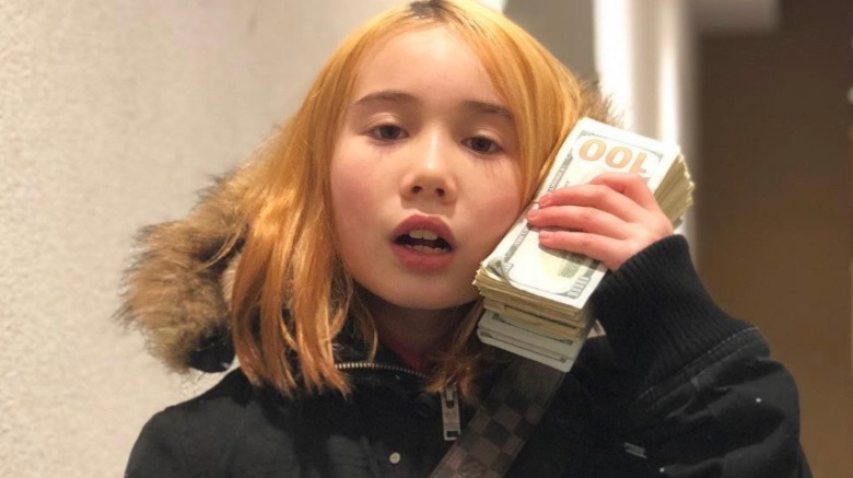 Lil Tay posing with a stack of cash