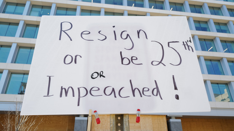 Sign reads 'Resign or be 25th'd or impeached.'