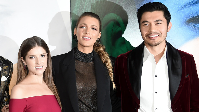 Blake Lively standing between Henry Golding and Anna Kendrick