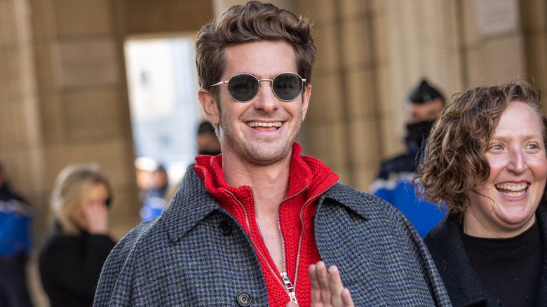 Andrew Garfield laughs and waves