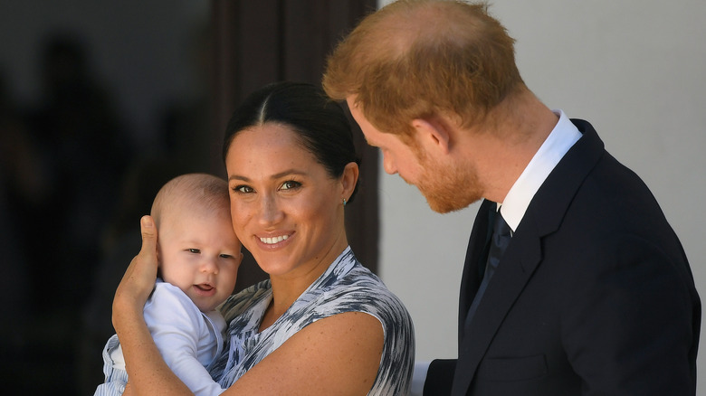 Meghan Markle smiles and holds baby Archie 