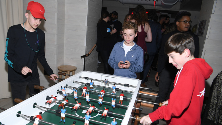 Backpack Kid Russell Horning playing foosball with kids