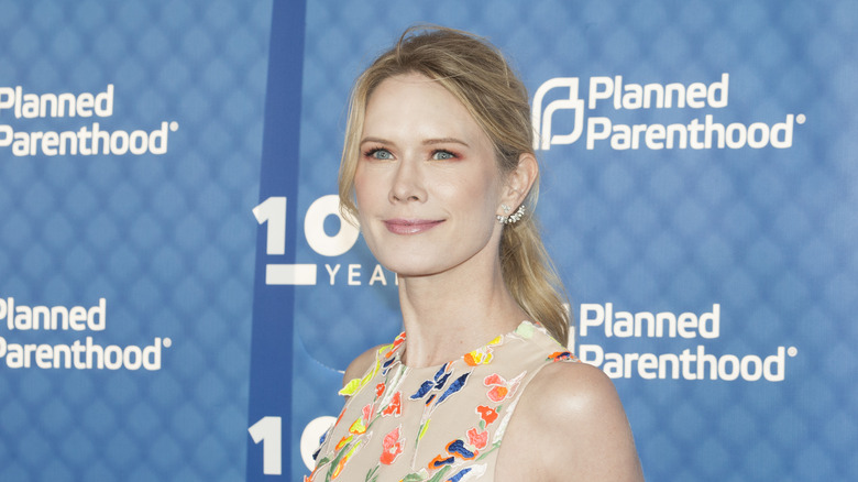 Stephanie March poses in front of a Planned Parenthood background