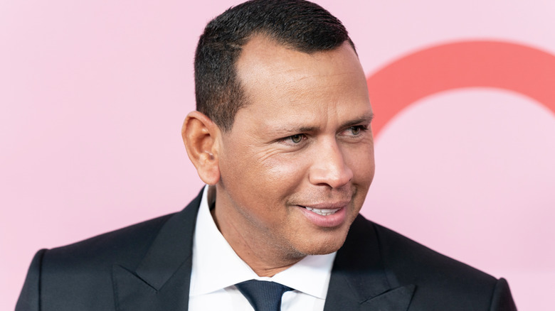 Alex Rodriguez smiling and looking to the side in a suit