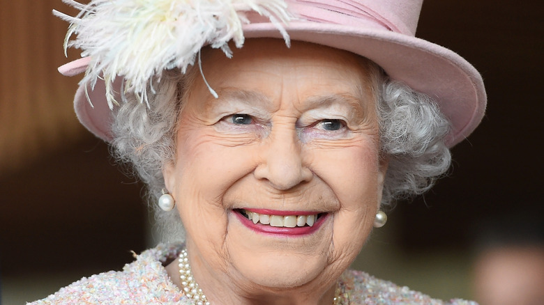 Queen Elizabeth II smiling in a hat 