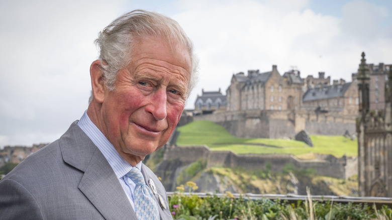 Prince Charles posing in front of castle