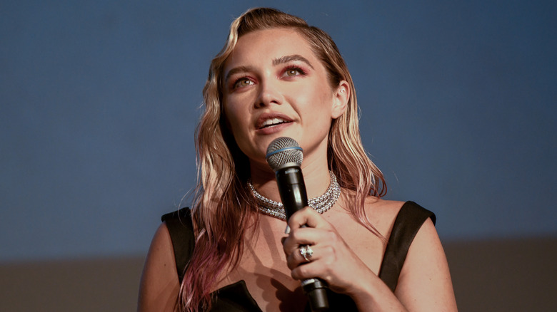 Florence Pugh onstage speaking into microphone