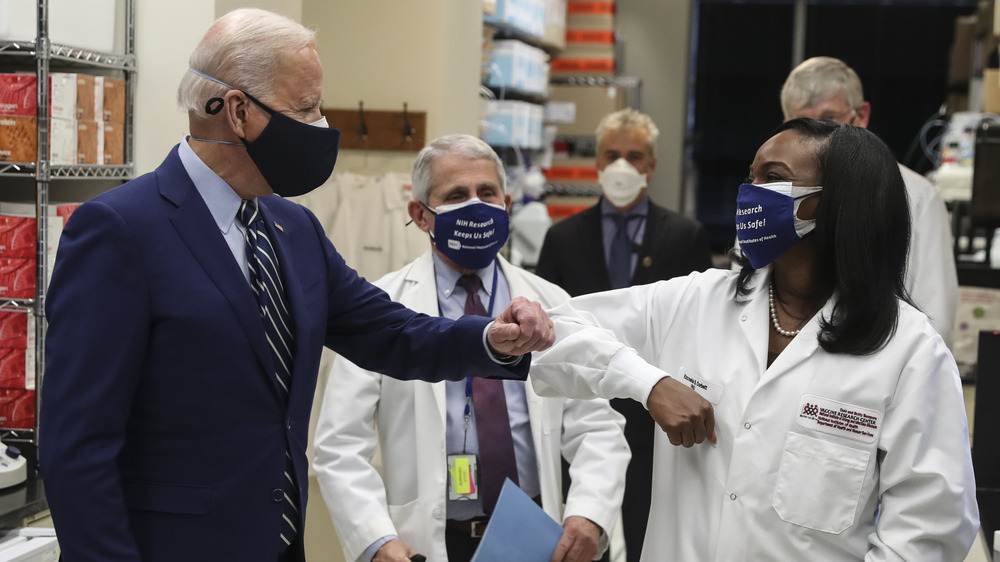 Joe Biden elbow bumps an immunologist