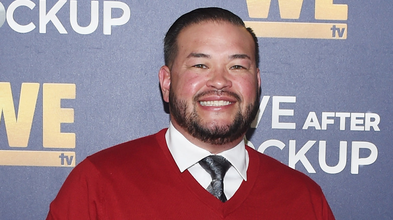 Jon Gosselin smiling in tie and red sweater