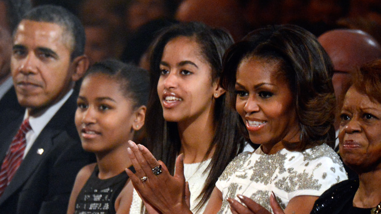 Malia and Sasha clapping with Michelle Obama