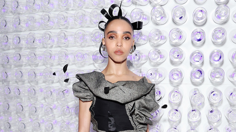 FKA Twigs posing in a black dress