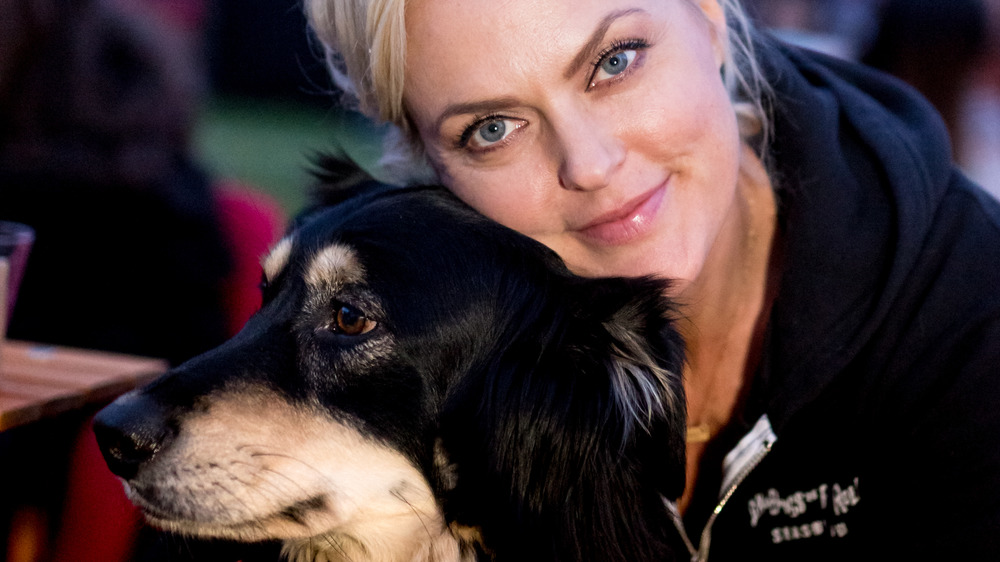 Elaine Hendrix cuddling with her dog at an event