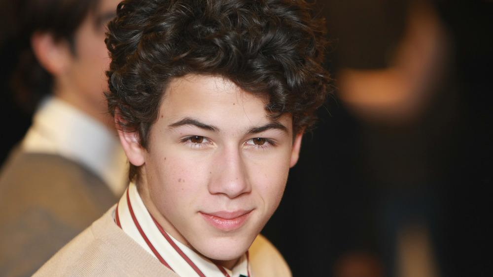 Nick Jonas as a teenager smiling for the camera