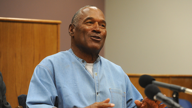 OJ Simpson smiling in front of microphones