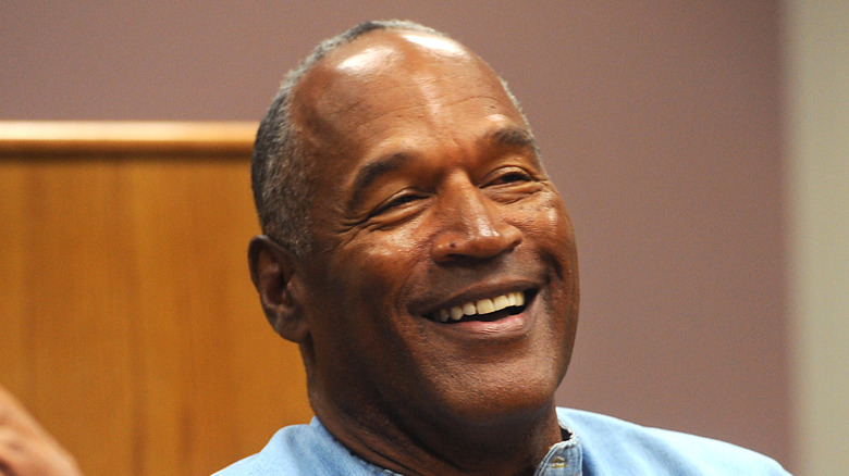 O.J. Simpson laughing in blue shirt