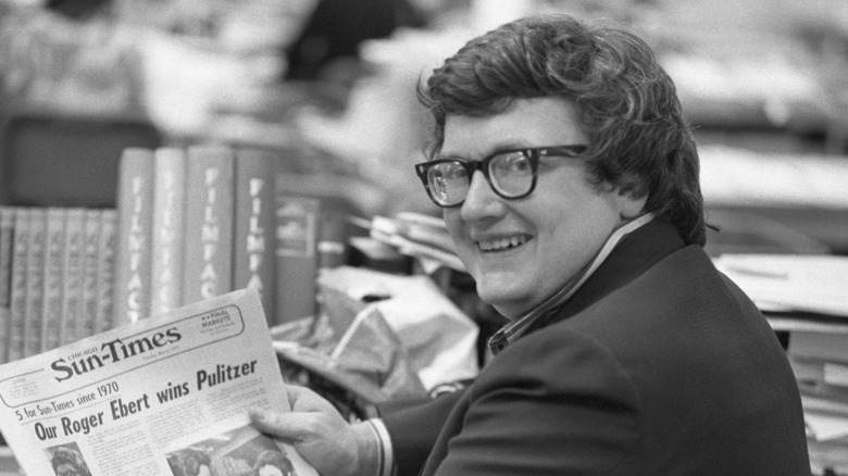 Roger Ebert poses with a newspaper.