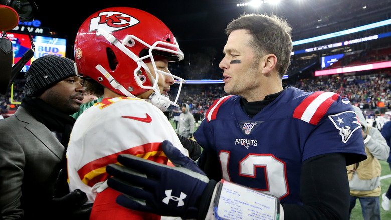 Tom Brady #12 of the New England Patriots talking with Patrick Mahomes #15 of the Kansas City Chiefs