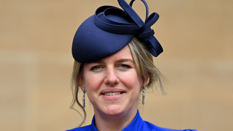 Laura Lopes smiling in a matching fascinator