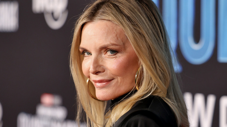 Michelle Pfeiffer smiles over her shoulder