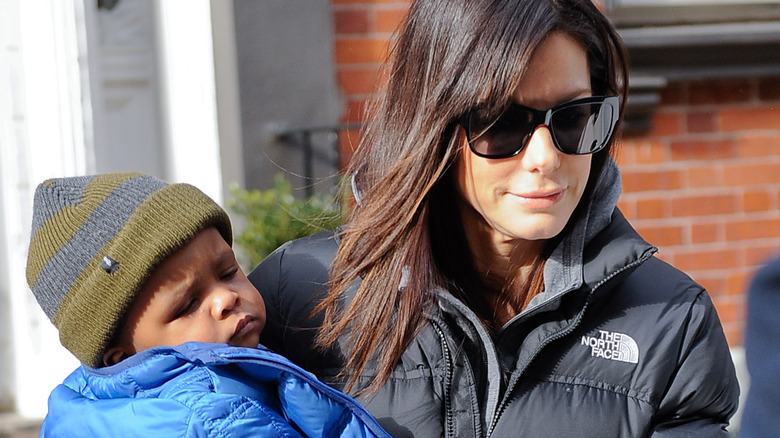 Sandra Bullock holding Louis as a toddler.