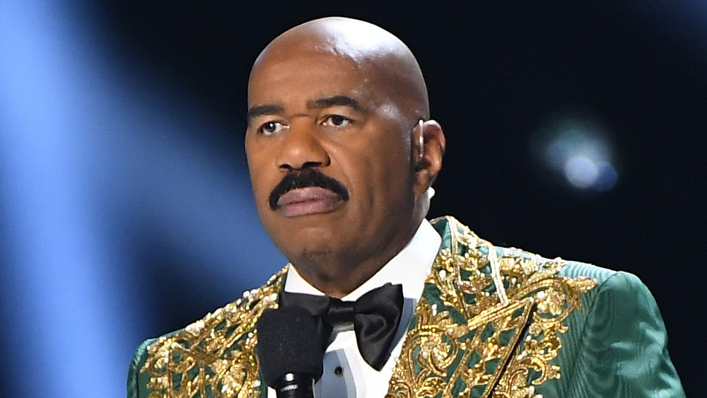 Steve Harvey standing in front of mic