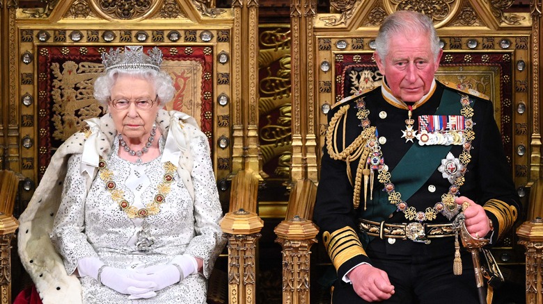 Queen Elizabeth II and Prince Charles sitting on their thrones