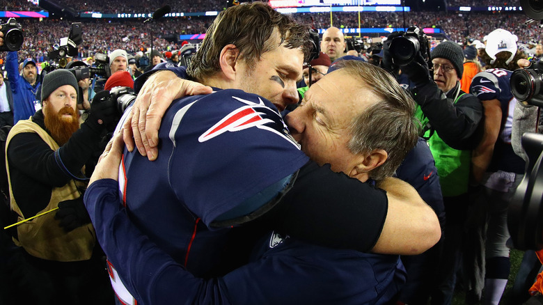 Bill Belichick and Tom Brady embrace on football field