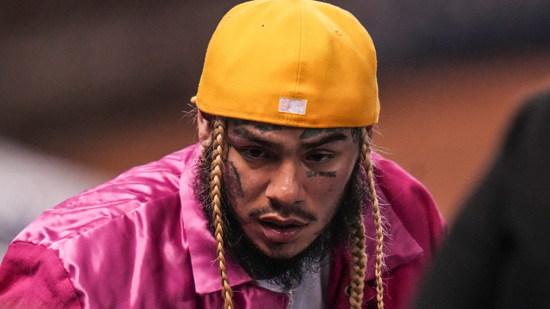 Tekashi 6ix9ine wearing purple hat and yellow cap